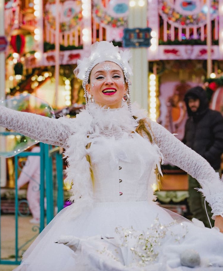 Echassier blanc de parade de noël devant carrousel en Occitanie
